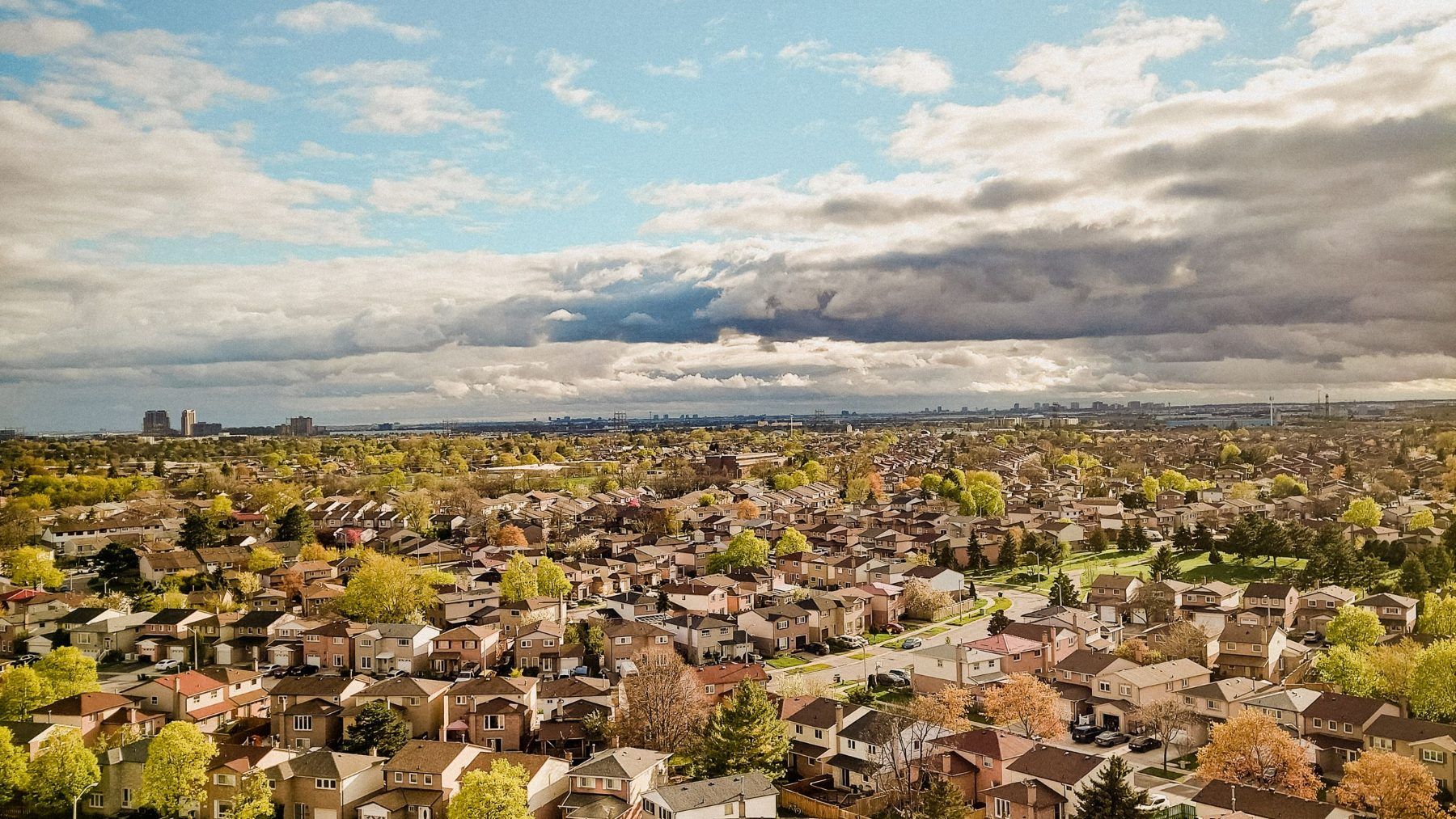 A sprawl of suburban houses under a wide sky