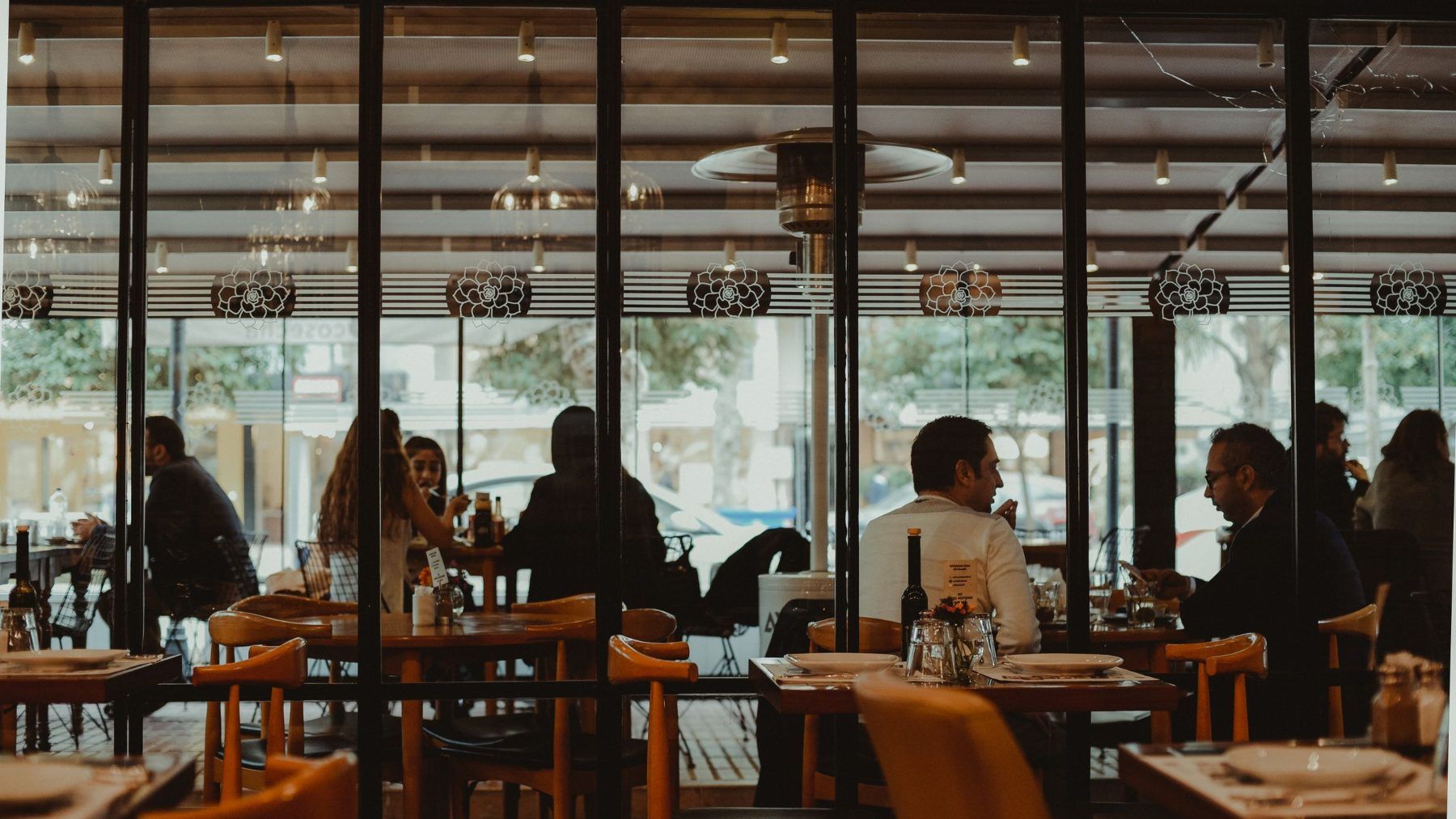 A restaurant interior at night seen from across the room, people at tables