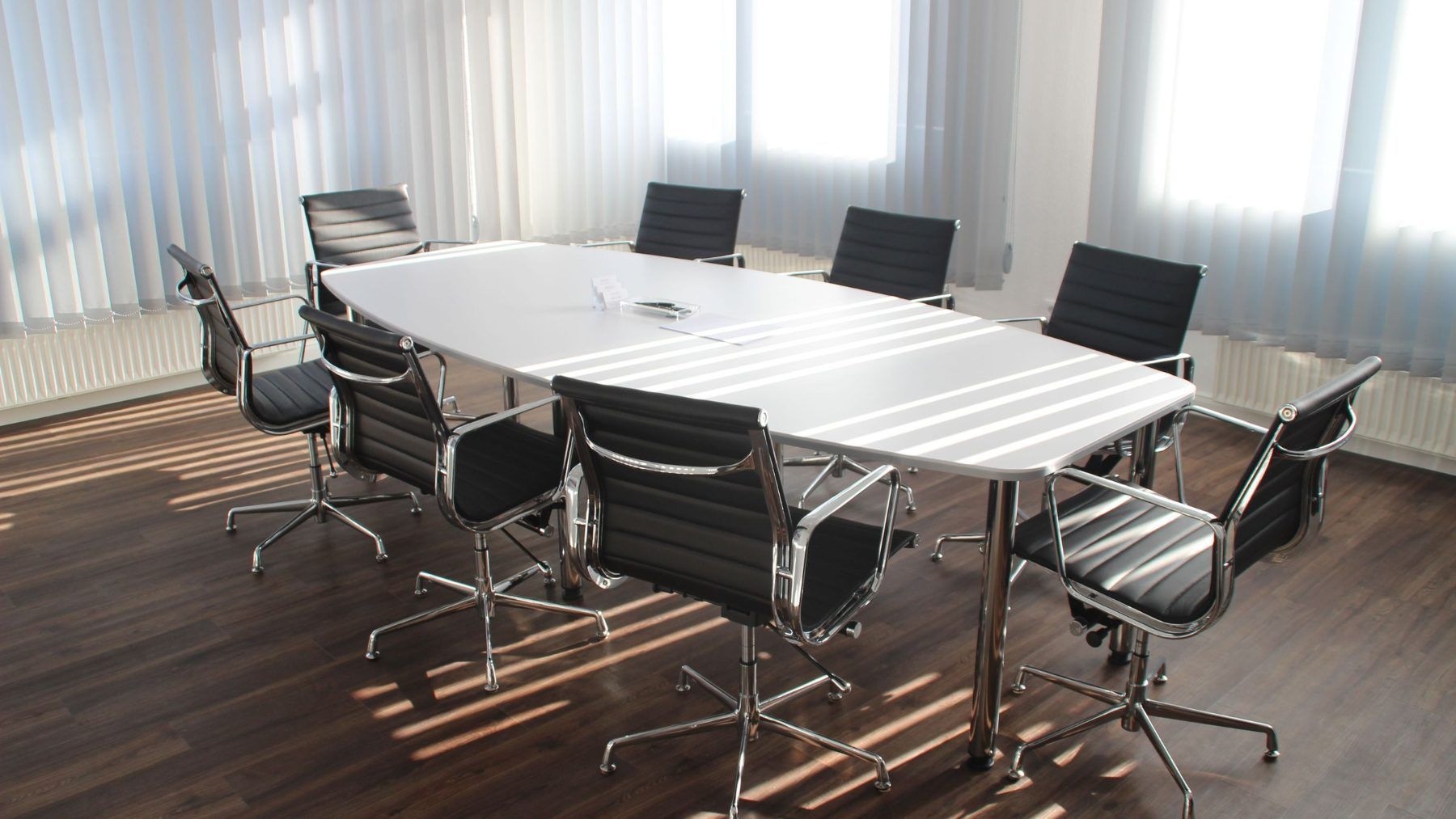 An empty boardroom with the blinds half drawn
