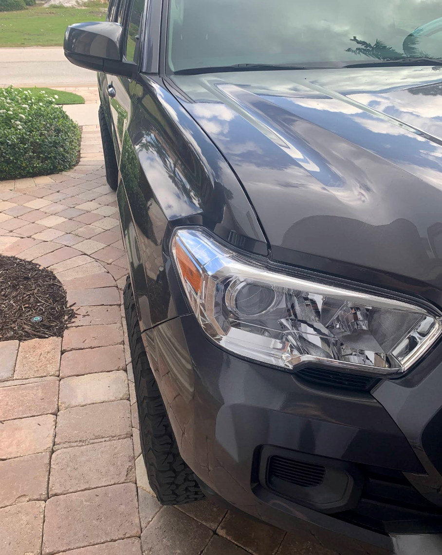 Dark gray SUV parked beside a brick walkway and bushes, front passenger side visible. | Mike's Garage