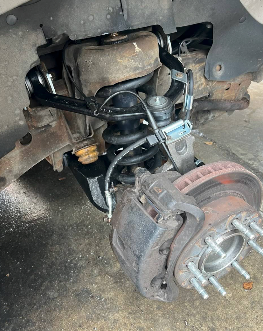 Car brake and suspension assembly with exposed rotor and wheel studs under the vehicle | Mike's Garage