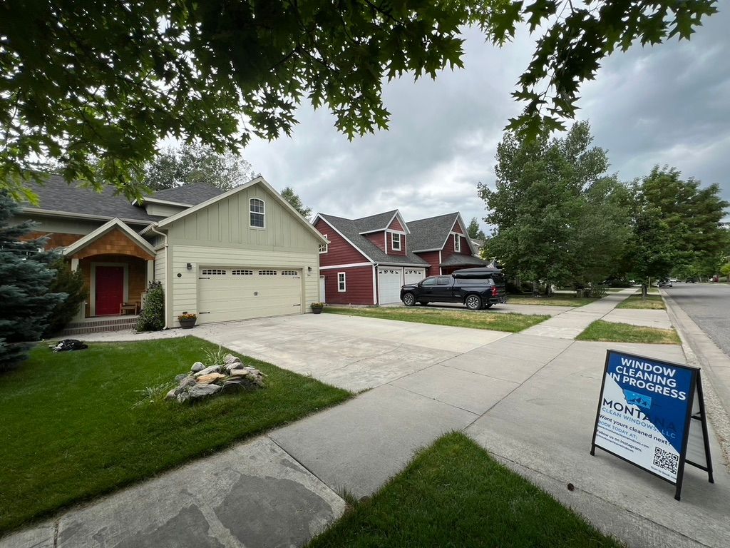 Suburban houses on a quiet street with a real estate sign on the lawn