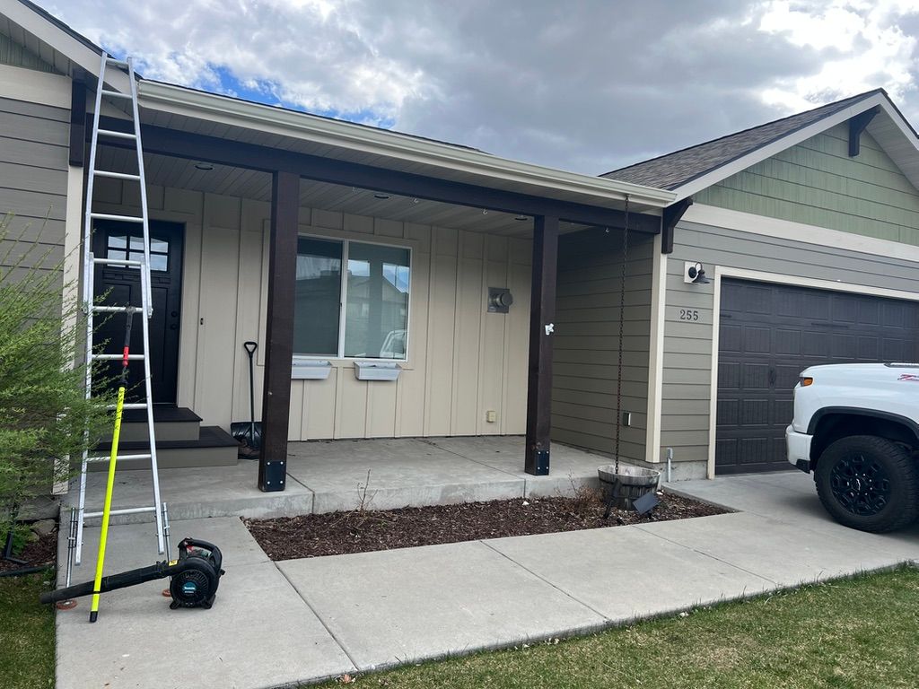 Front porch of a house under repair, with a ladder, tools, and a white truck in the driveway.