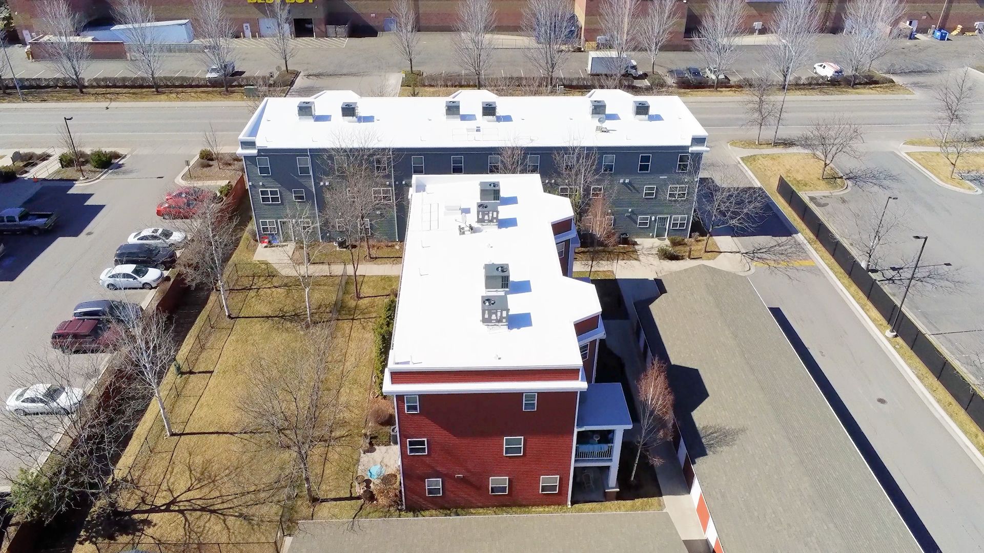 Fluid-applied commercial roof coating being installed over an eligible low-slope roofing system
