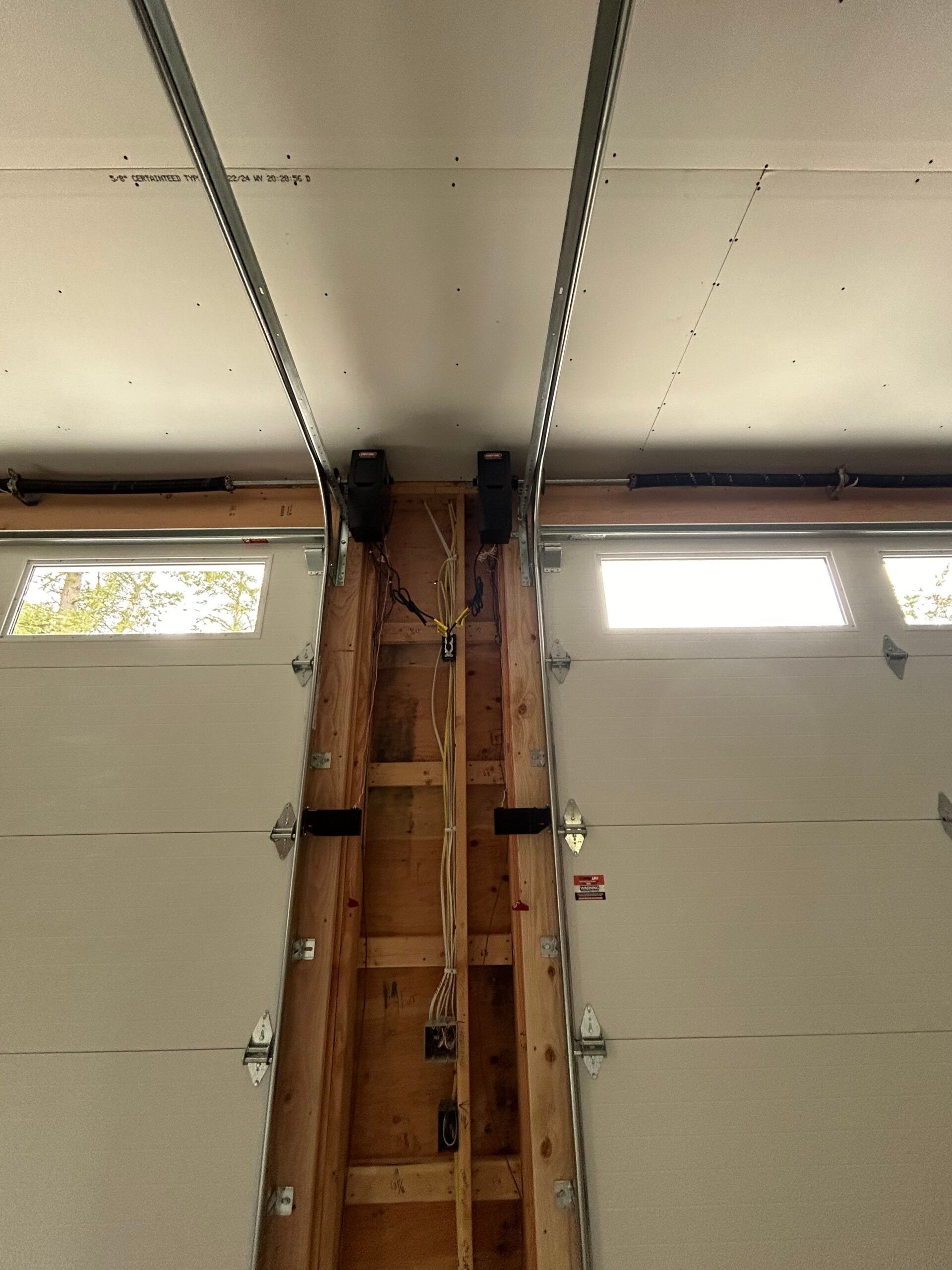 Interior view of a garage door opening with exposed wooden frame and overhead tracks
