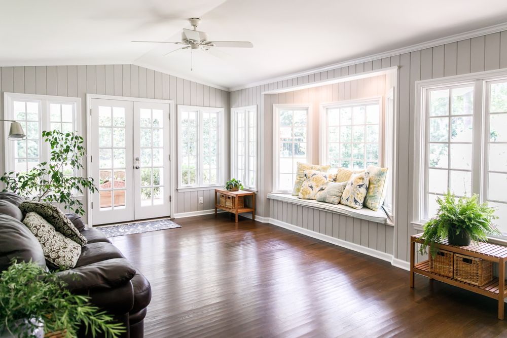 Living room with dark wood floors, a window seat, and French doors.