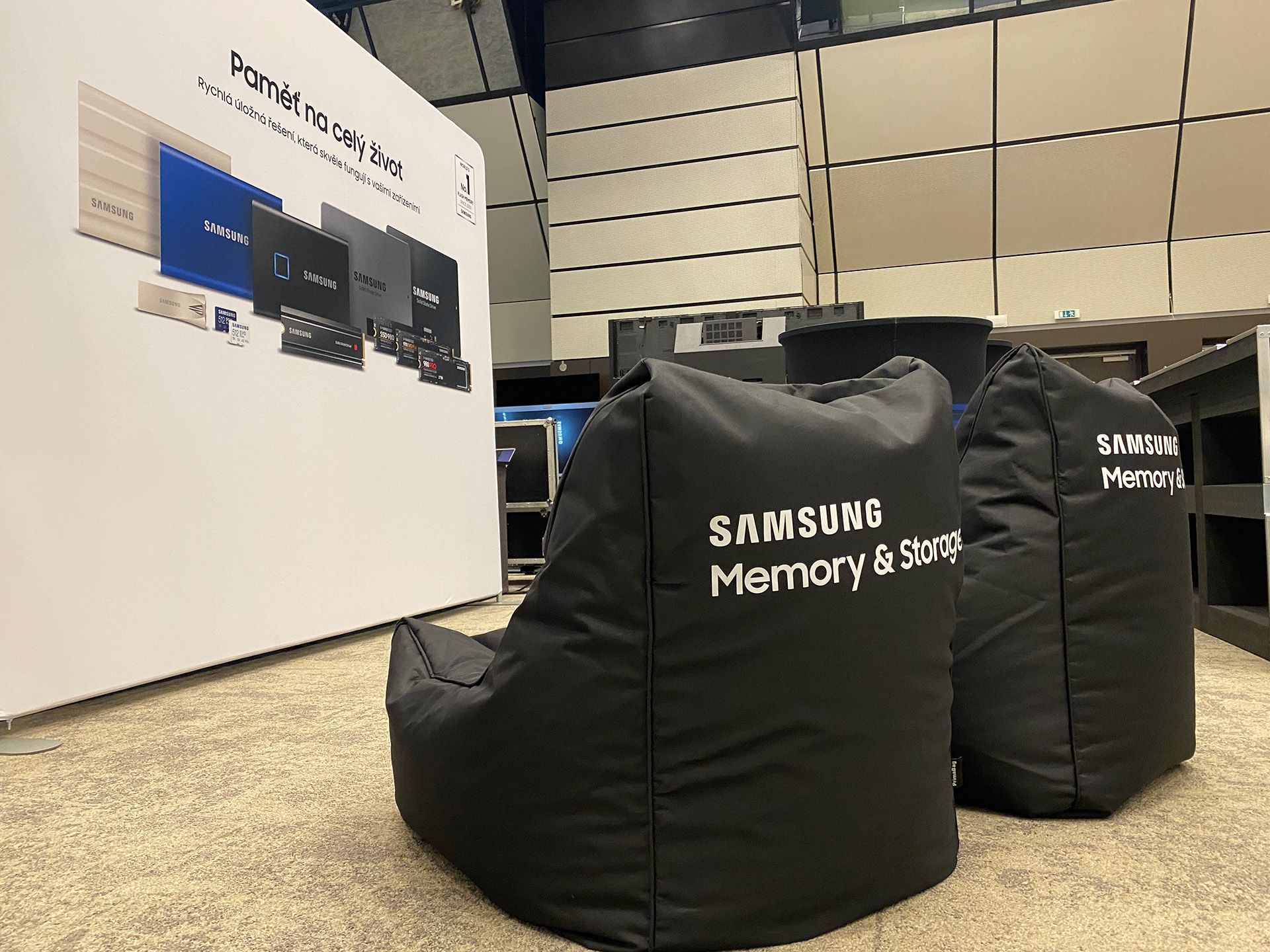 Černé sedací vaky Samsung Memory ve výstavní ploše technologického stánku s nástěnnou grafikou a monitory v pozadí