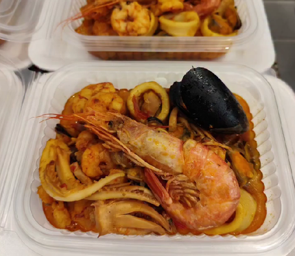 Pasta con mariscos para llevar, con camarones, mejillones y calamares en envases de plástico.