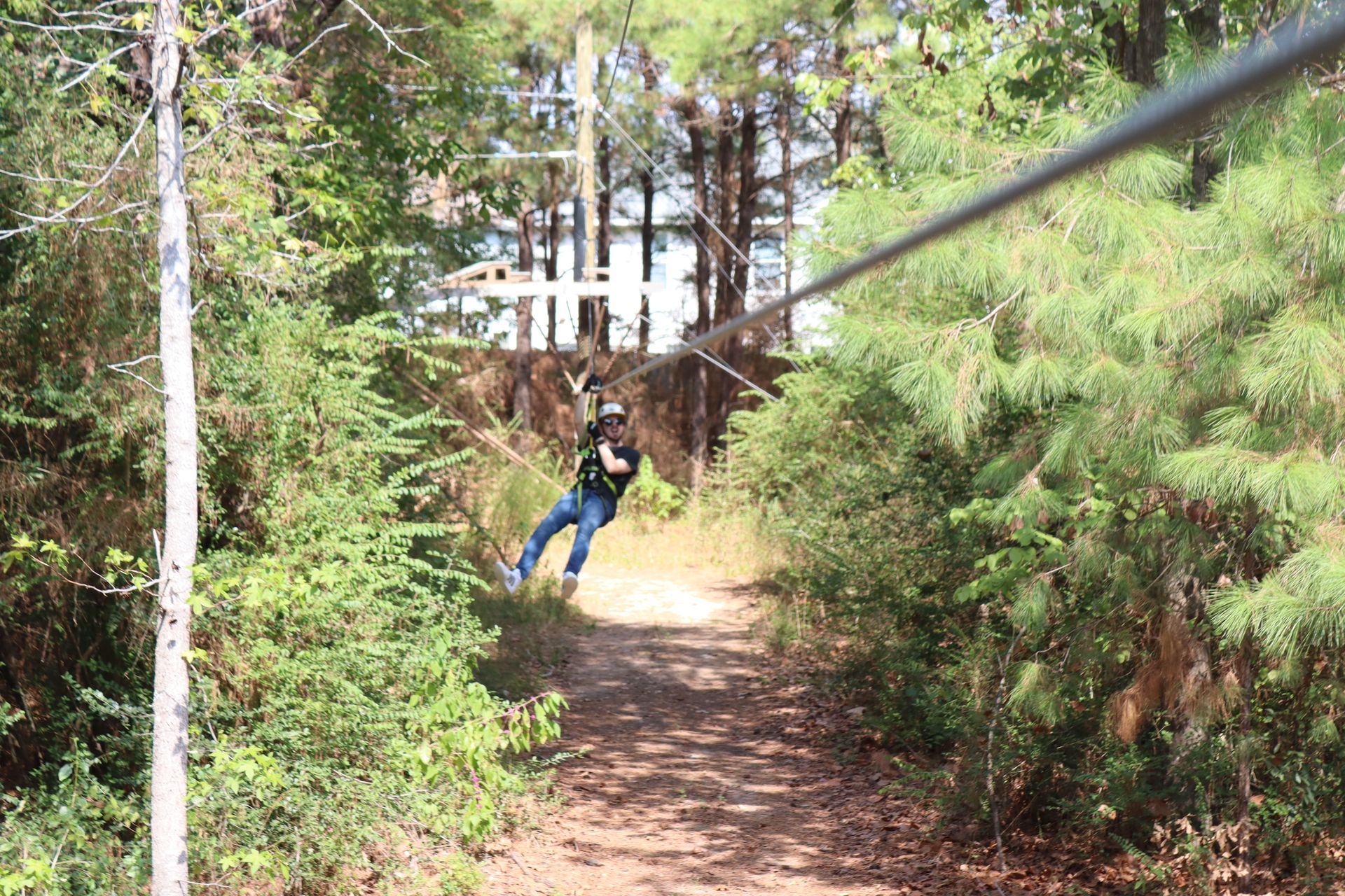 Person balancing on suspended wooden steps in a forest ropes course