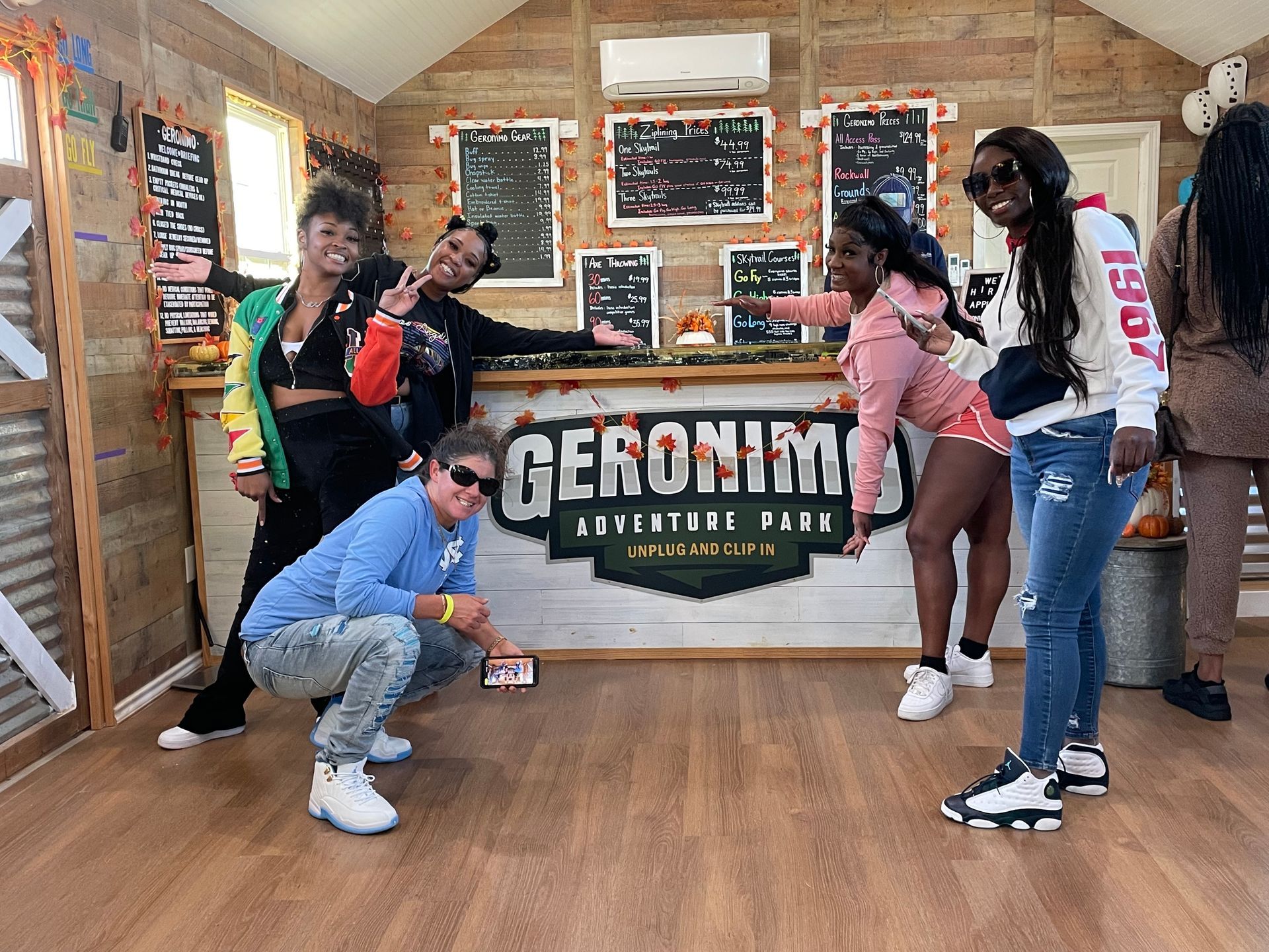 Four people posing in a rustic room beside a 