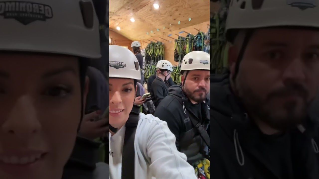 Helmeted people posing for a selfie in a warmly lit indoor venue.