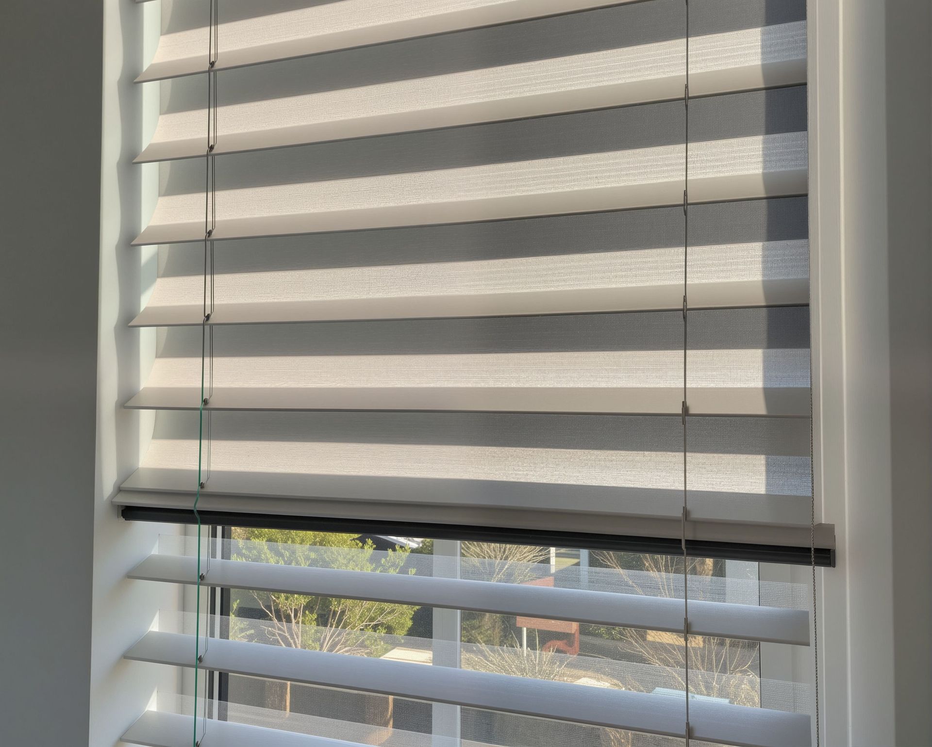 Living room window dressed in hunter douglas honeycomb shades filtering soft warm natural daylight.