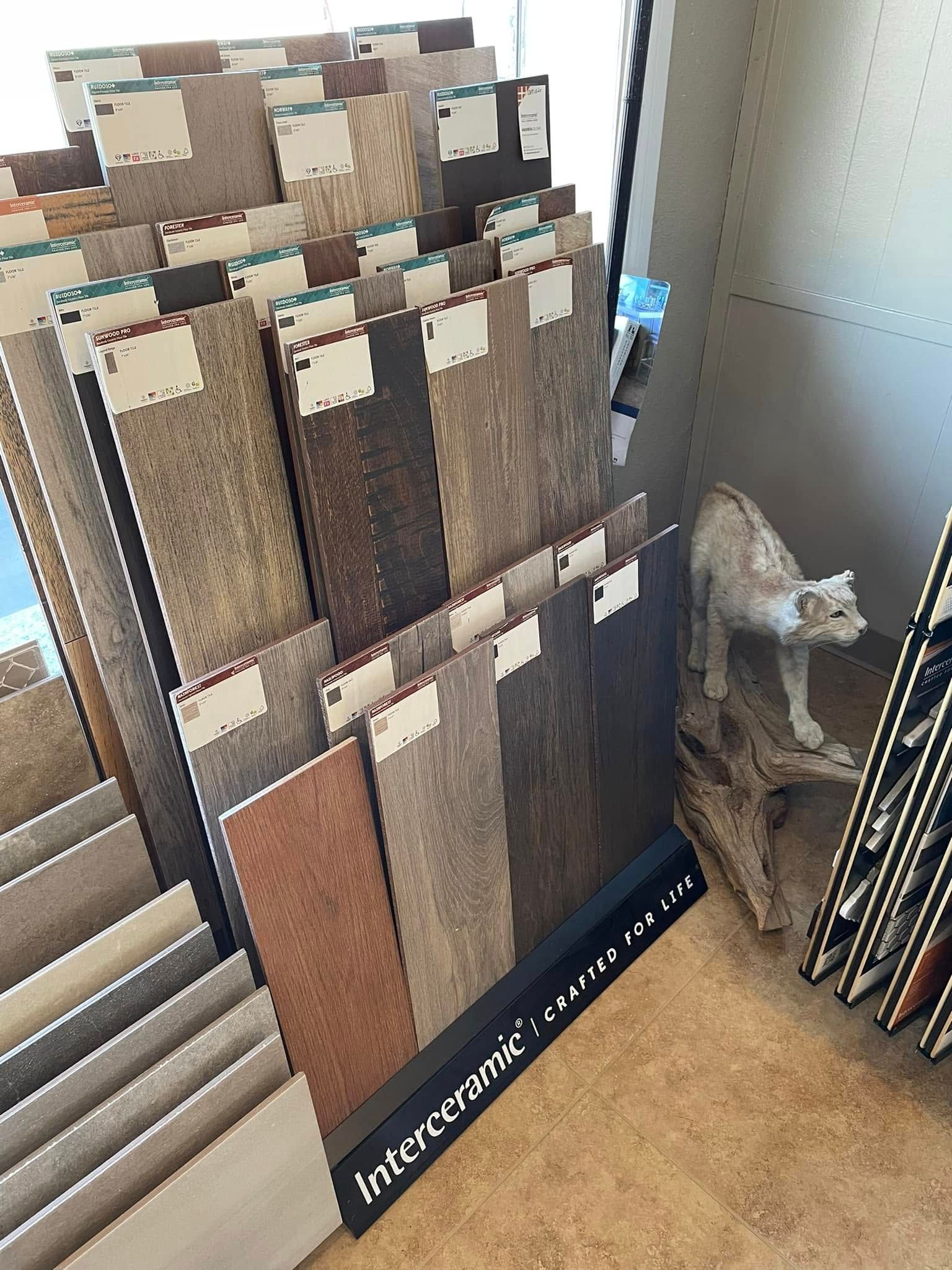 Display rack of carpet swatches beside stacked floor mats in a showroom