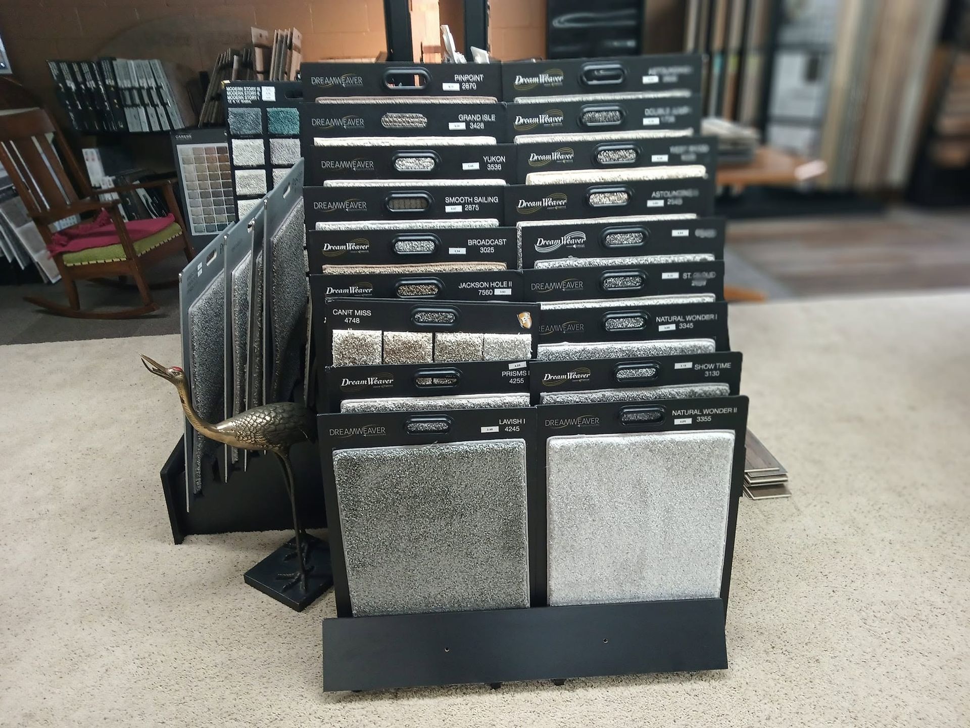 Stacked black sample boards with stone and tile swatches displayed in a showroom.