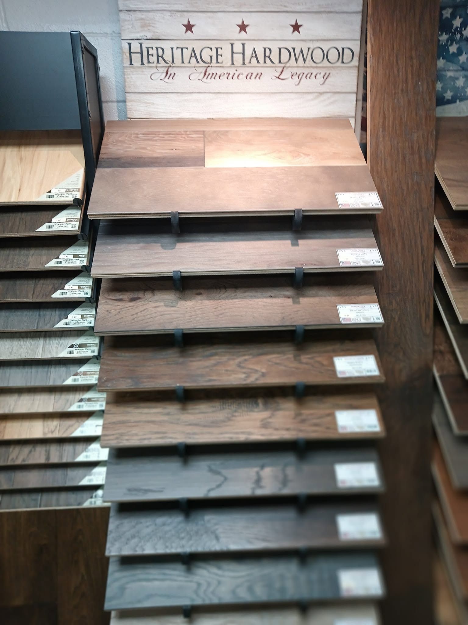 Display of Heritage Hardwood flooring samples in a showroom, with rows of wood planks on shelves.