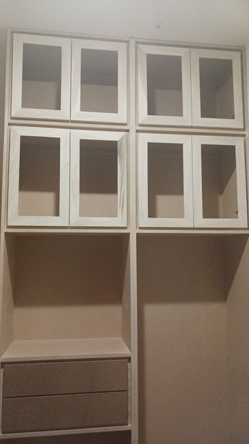 Wall-mounted white-and-brown cabinet with glass-front upper doors and drawers below.