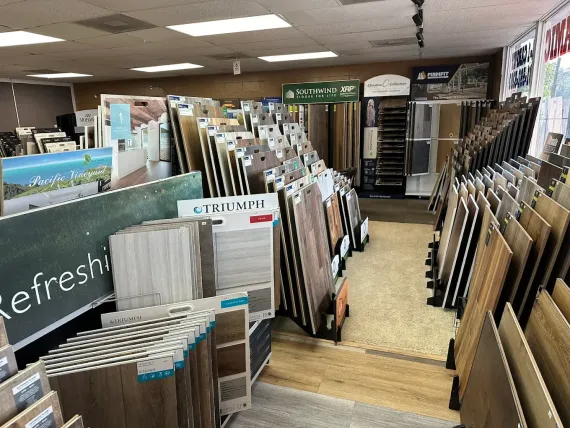 Bookstore aisle with many display racks of framed prints and posters, including a chalkboard sign reading “Refreshment.”