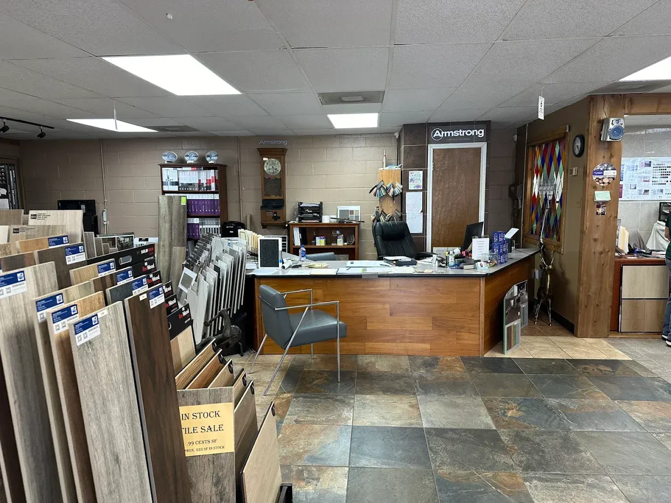 Office lobby with reception desk, file racks, and chairs in a small business space