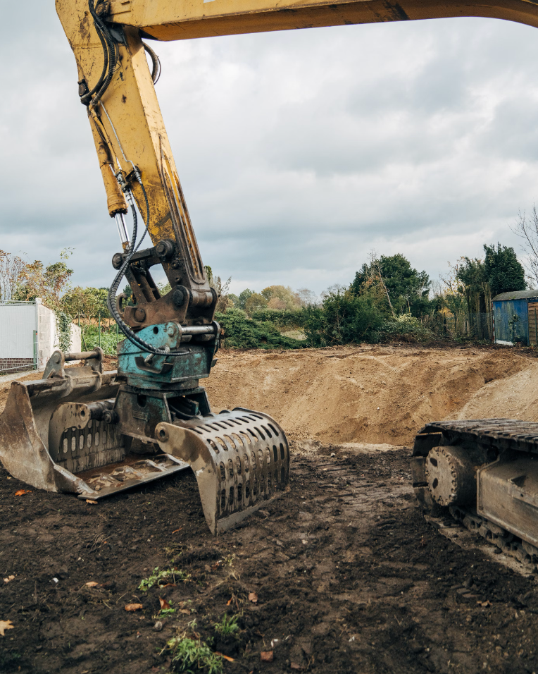 A large excavator is sitting in the dirt on a construction site.