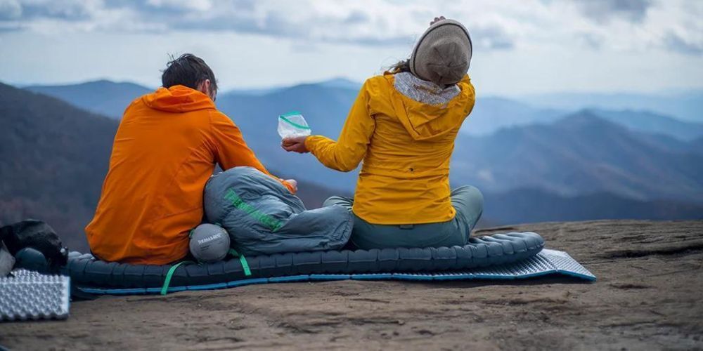 a couple sitting on their sleeping pad