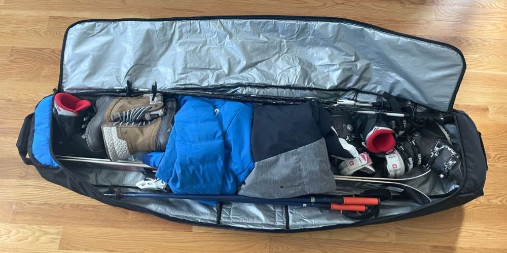 A snowboard is sitting in a bag on a wooden floor.