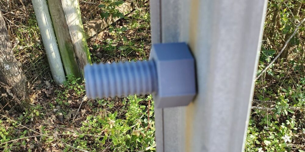 A close up of a bolt on a metal pole.