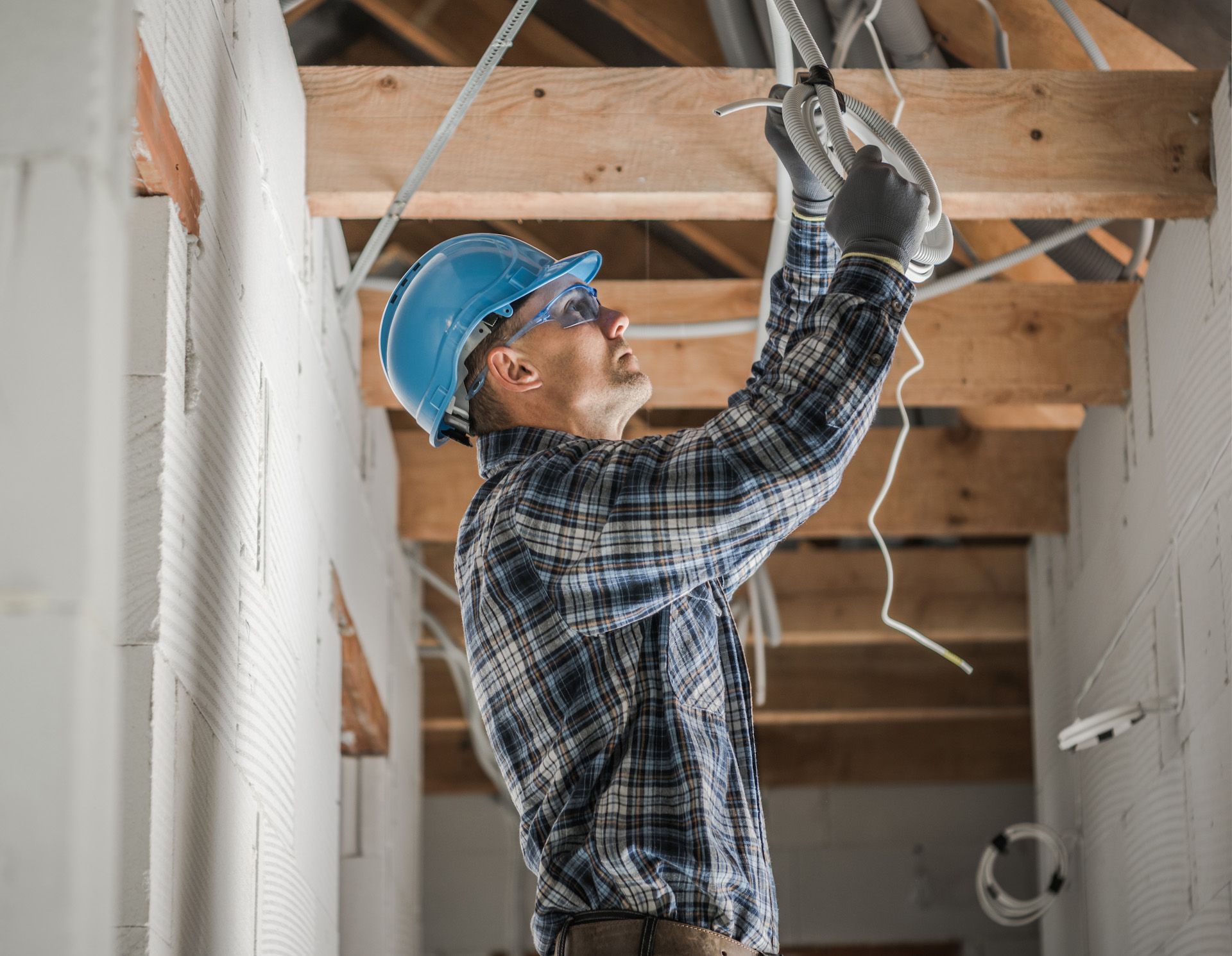 A man is working on the ceiling of a building.