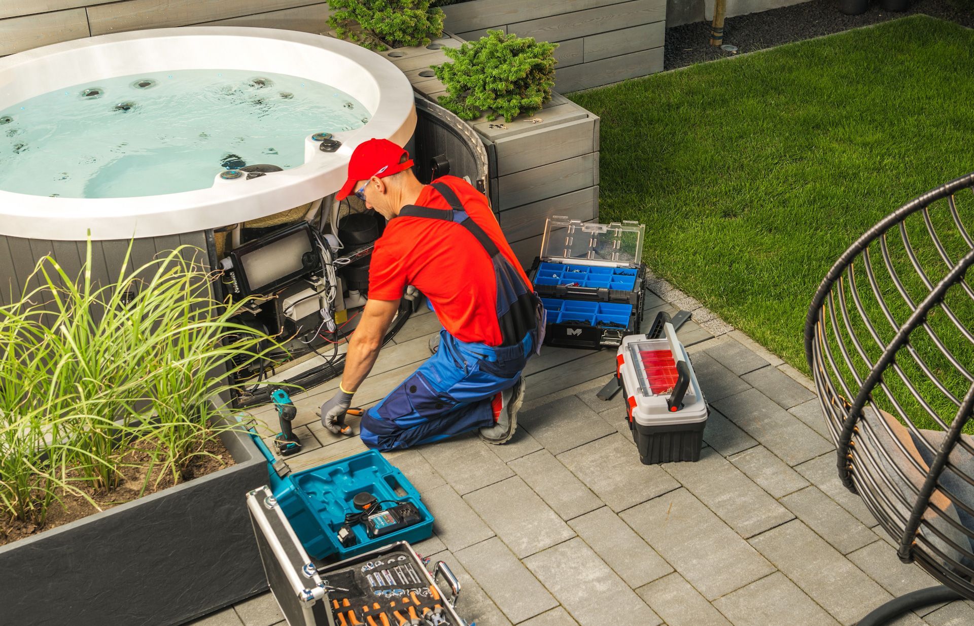 A man is working on a hot tub on a patio.