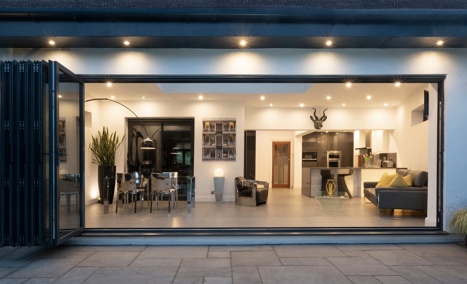 A large sliding glass door is open to a living room and kitchen.