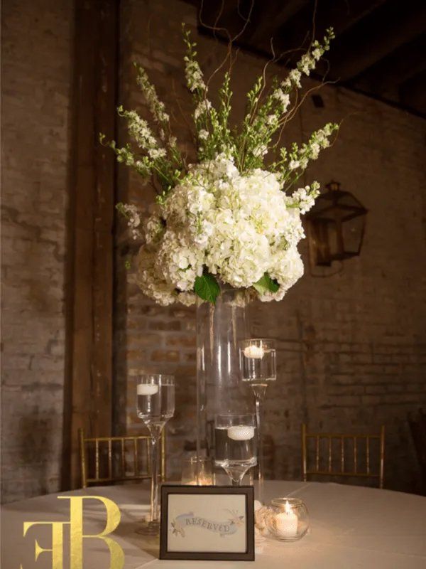 White flowers on vase and glasses with candles