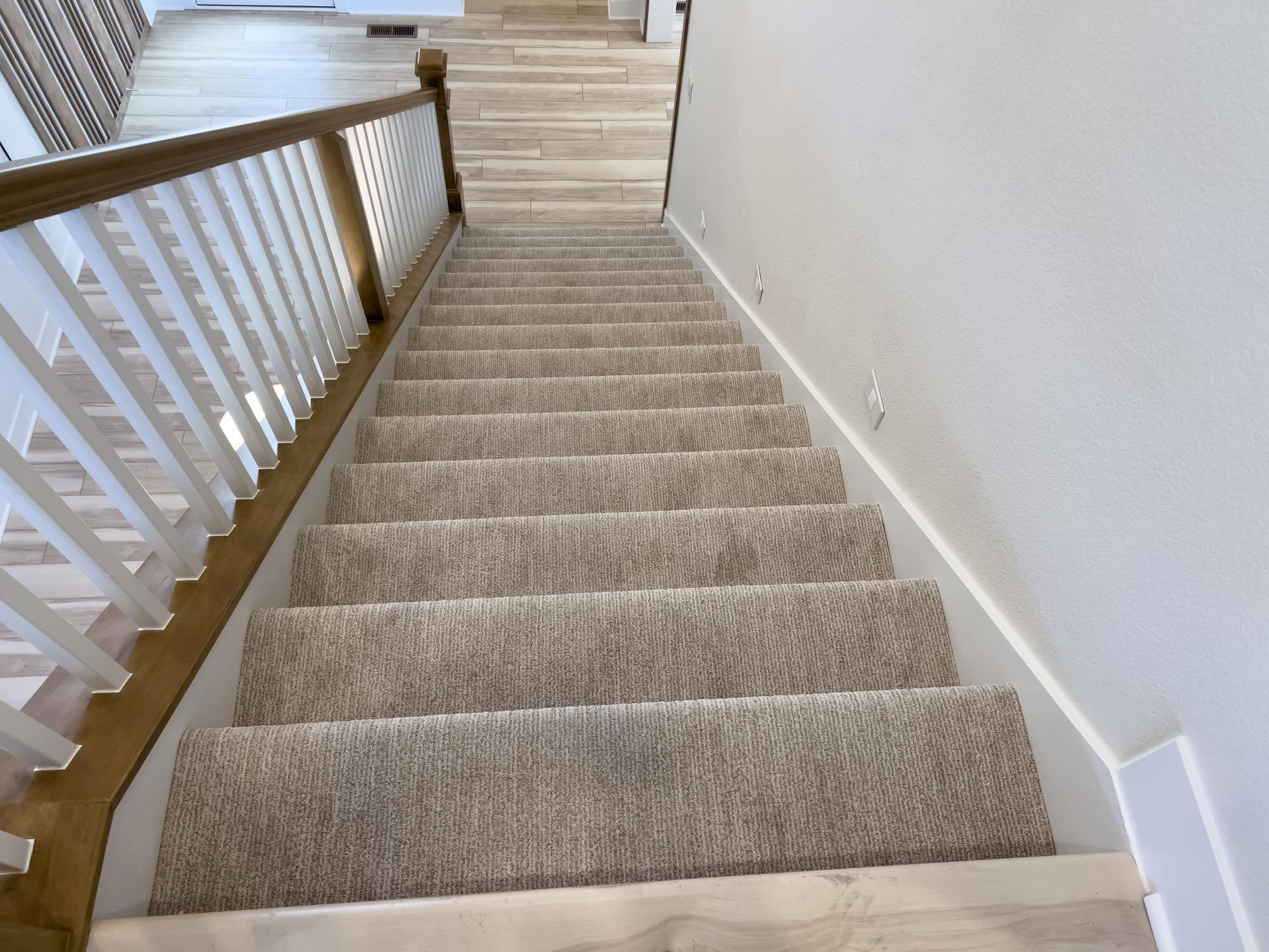 The stairs are carpeted and have a wooden railing.