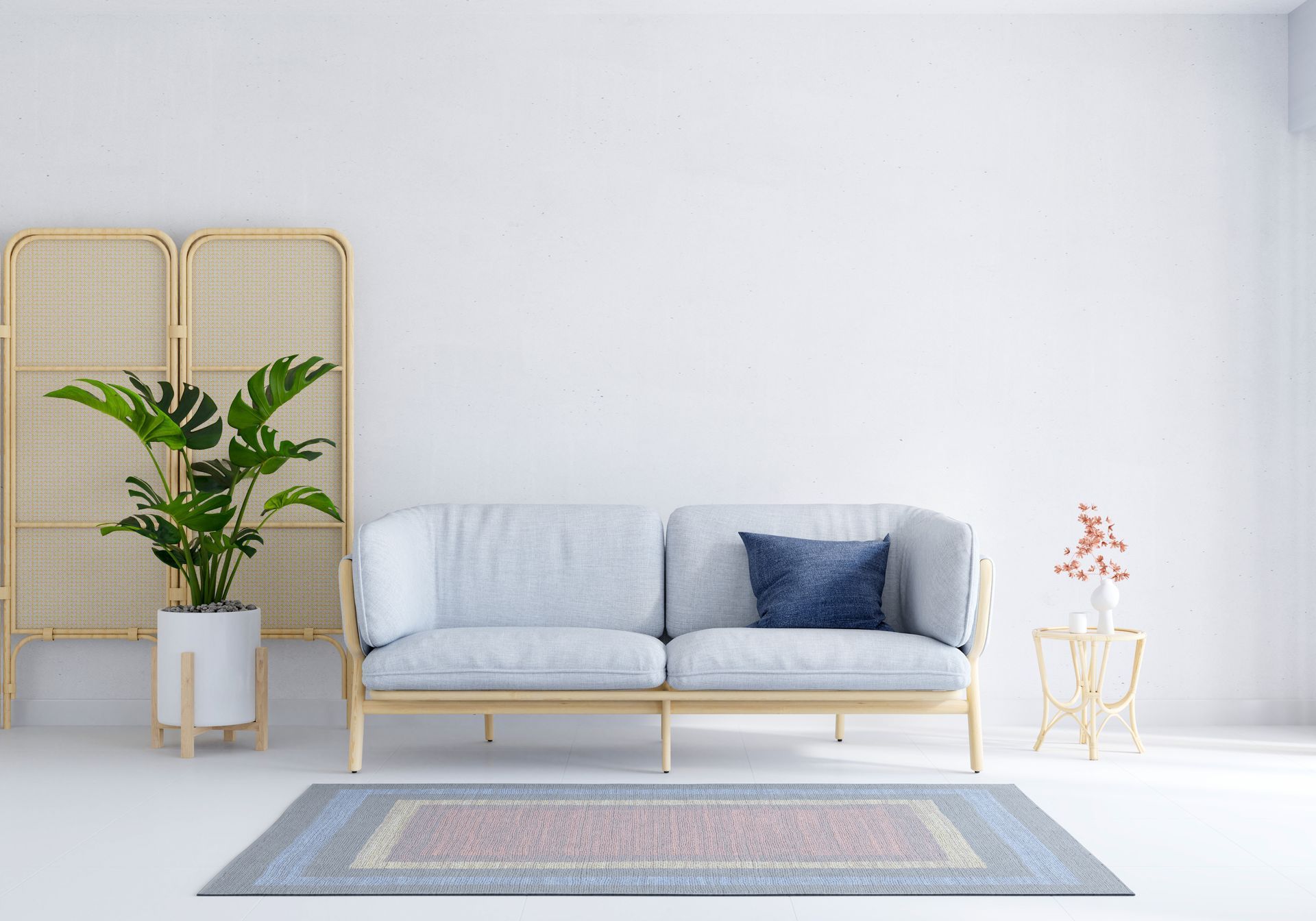 A modern living room with a light blue sofa, a Monstera plant, and a small gold table.
