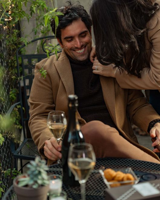 Champagne club members enjoying a bottle of champagne together outside.