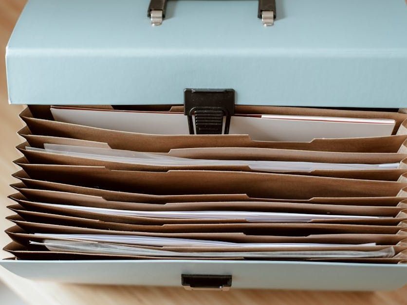 Open light blue file box with several manila folders stacked inside