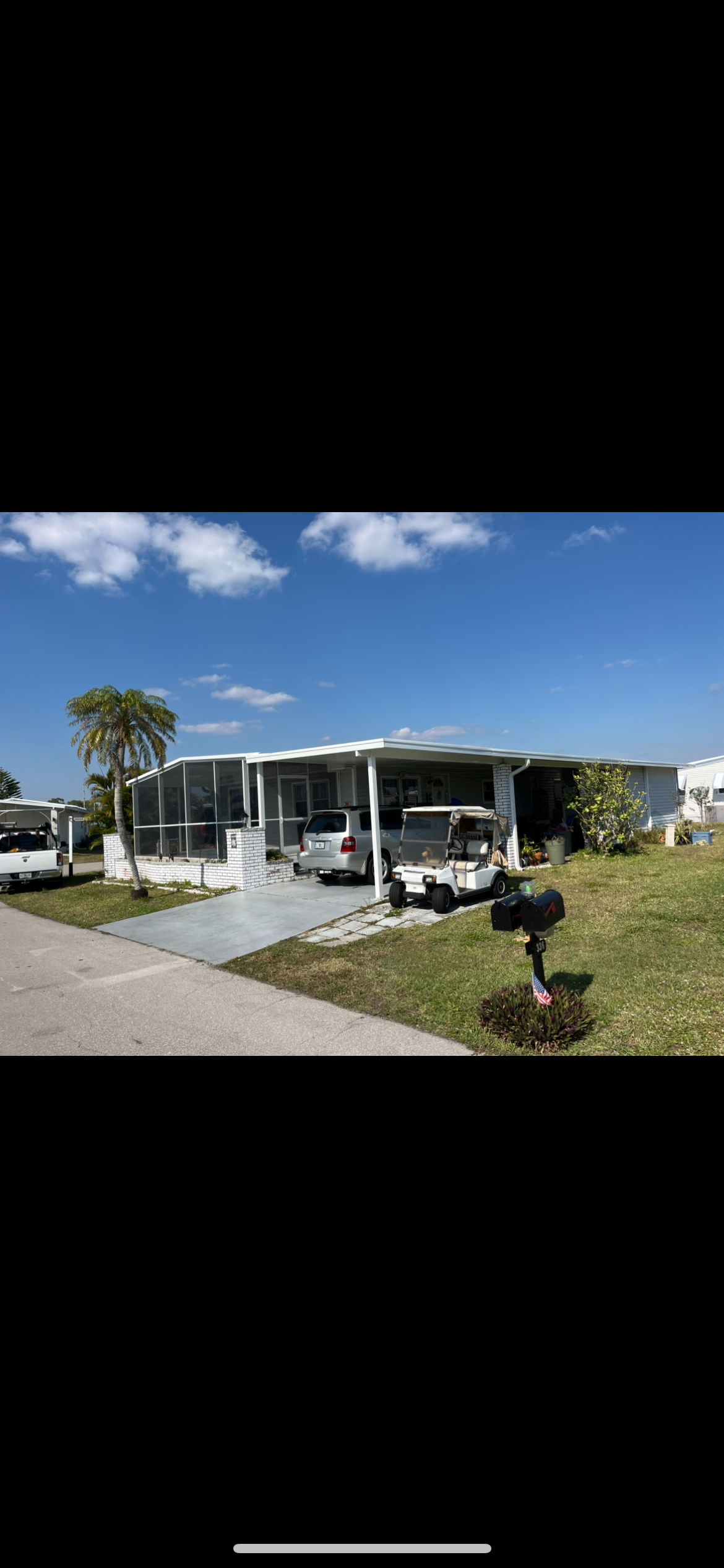 A mobile home with a mailbox in front of it.