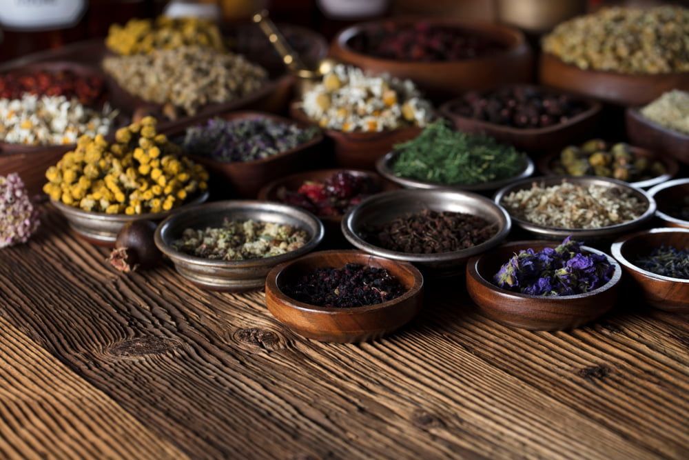 A Wooden Table Topped With Bowls Of Dried Herbs — Naturopath Australia In Mermaid Beach, QLD