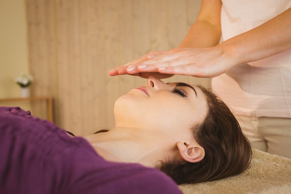 A Woman In A Purple Shirt Is Getting A Healing Treatment — Naturopath Australia In Mermaid Beach, QLD