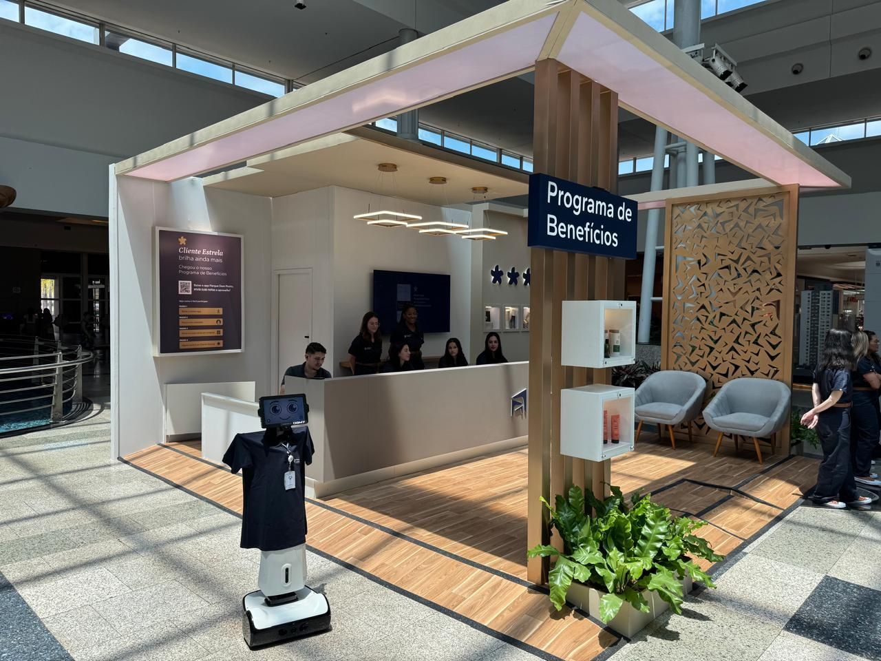 Um robô está parado em frente a uma cabine em um aeroporto.