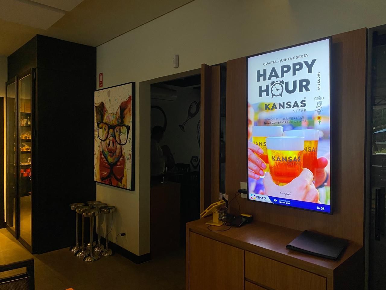 Uma sala com uma placa na parede que diz `` happy hour kansas ''.