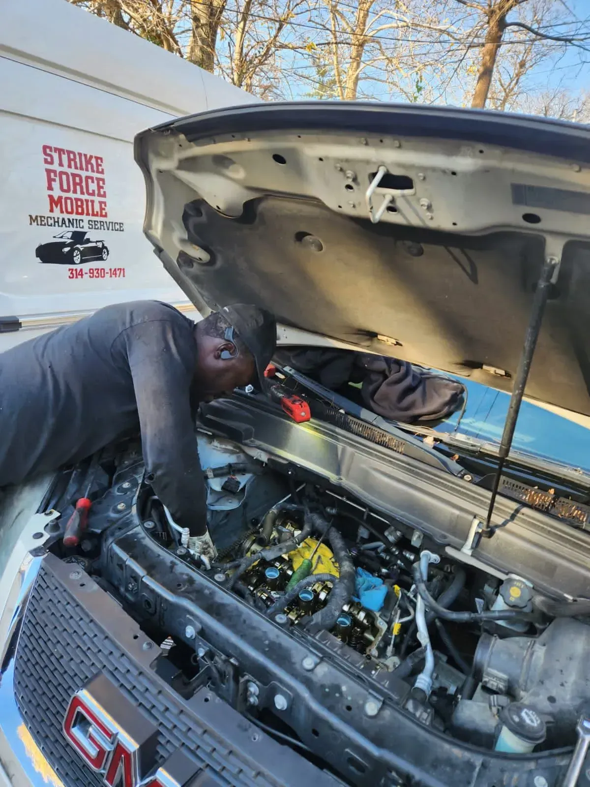 a man seeing in the bonet | Strike Force Mobile Mechanic llc
