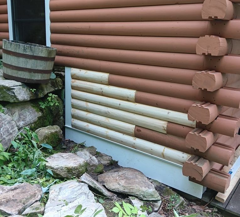 A log cabin with a section of wood repaired by American Log Home Care