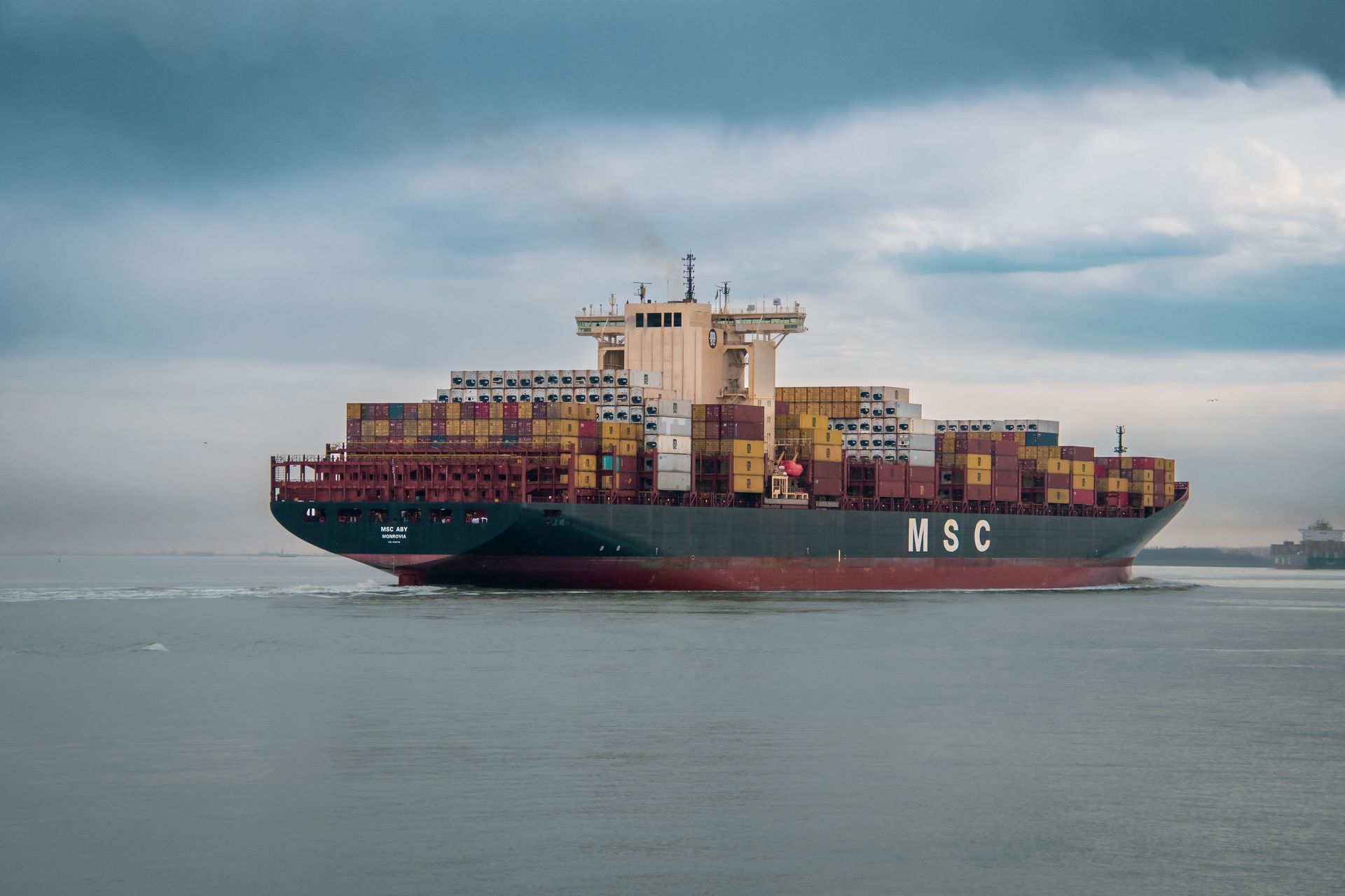 An ocean freighter stacked with shipping containers.
