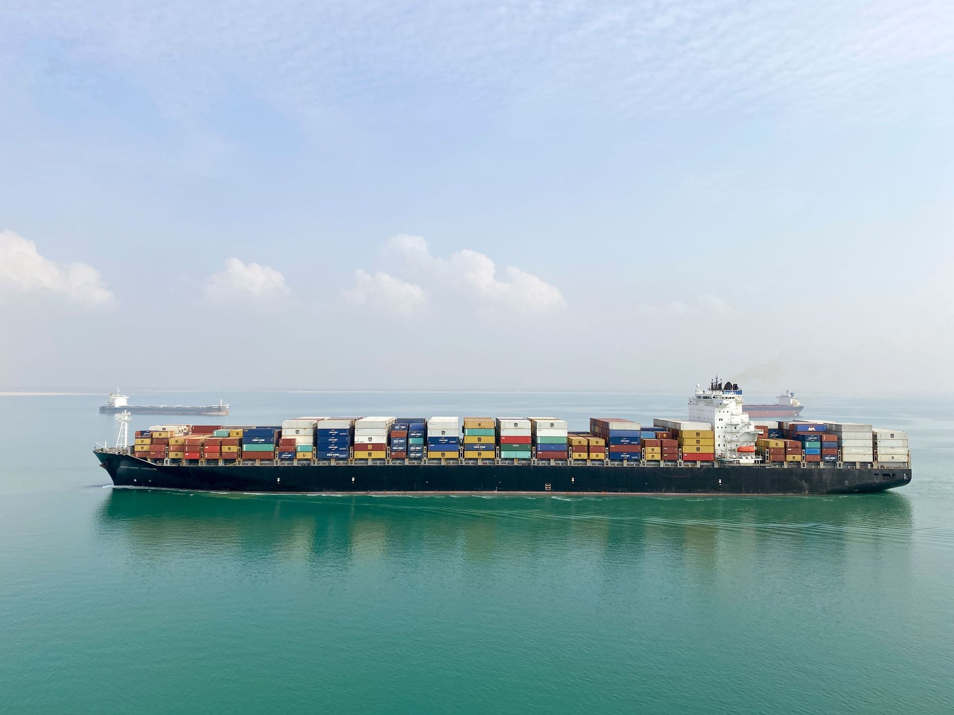 A long ocean freight ship with shipping containers stacked on it