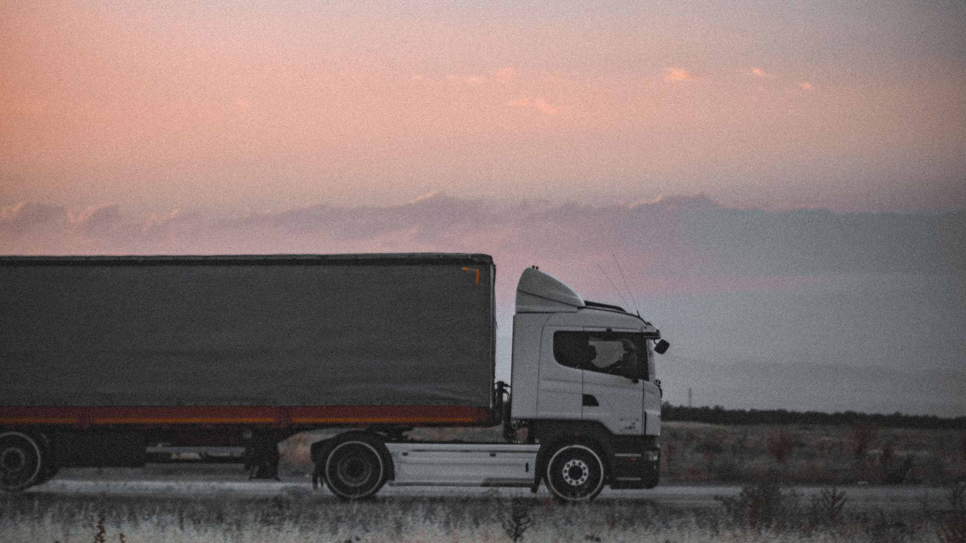 A freight truck with mountains in the background.