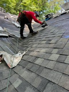 A man is working on the roof of a house.
