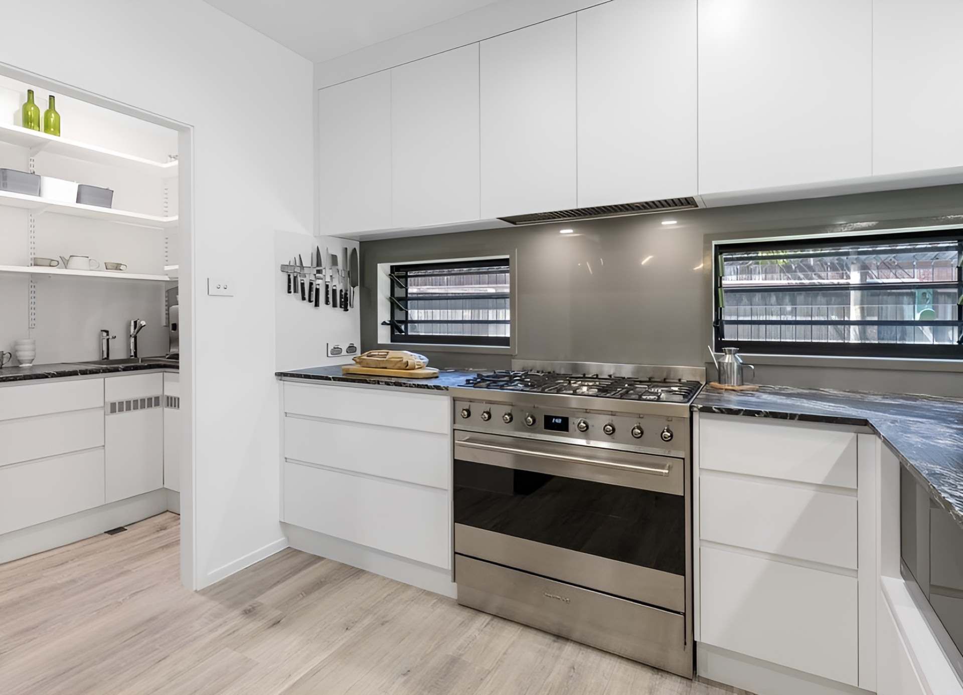 A Kitchen With Stainless Steel Appliances and White Cabinets — Kitchens by CCJS in Mission Beach, QLD