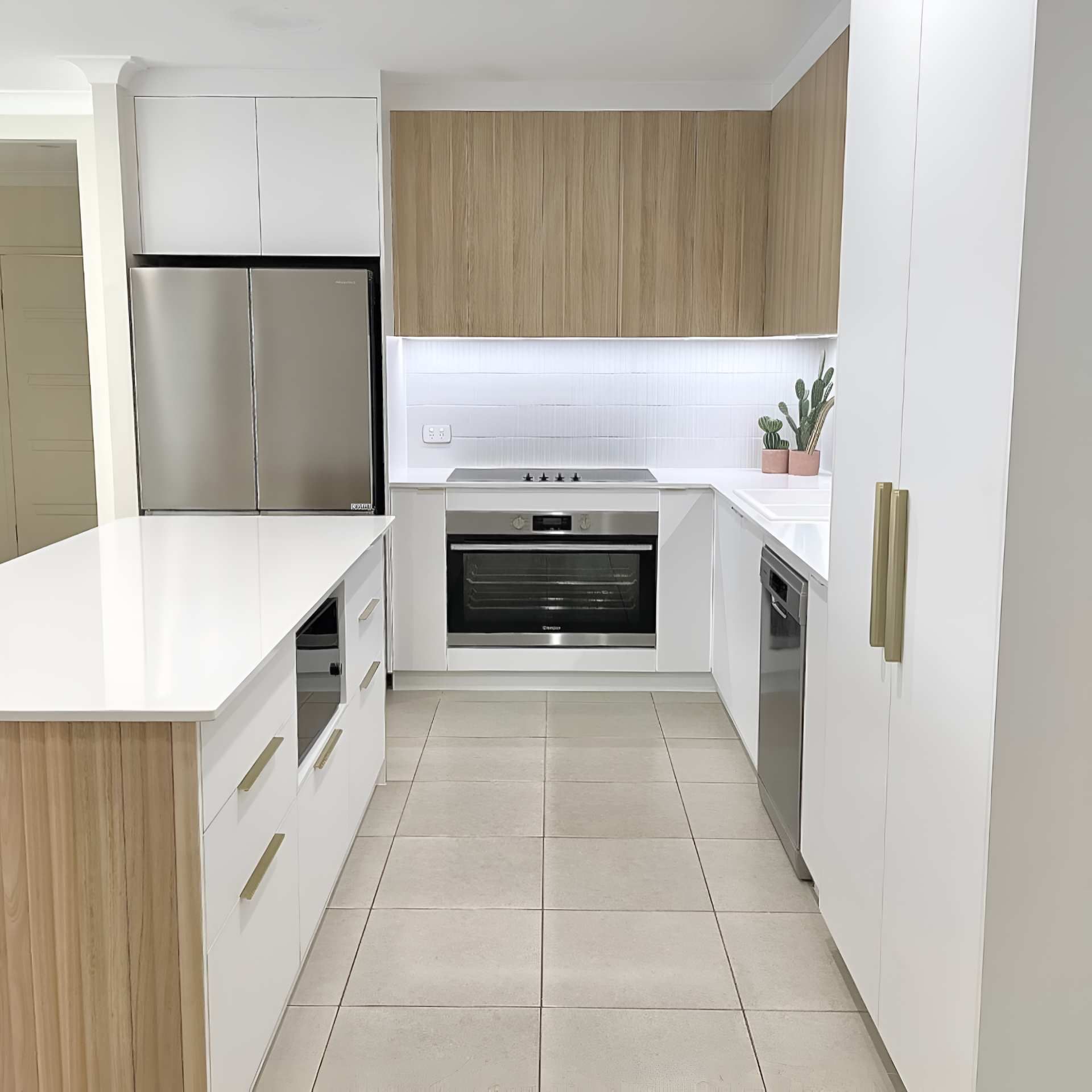 A Kitchen With Stainless Steel Appliances and Wooden Cabinets — Kitchens by CCJS in Mission Beach, QLD
