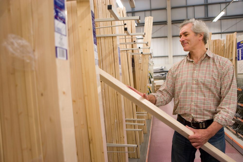 Man in a Hardware Store, Selecting Lumber From a Display Rack โ Kev's Group QLD in Kawana, QLD