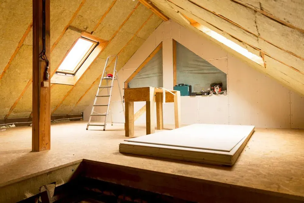 Attic Interior With Skylights, Insulation, Small Work Tables, and a Mattress on the Floor — Kev's Group QLD in Kawana, QLD Attic Interior With Skylights, Insulation, Small Work Tables, and a Mattress on the Floor — Kev's Group QLD in Kawana, QLD