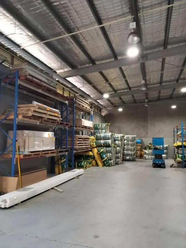 — Kev's Group QLD in Kawana, QLD Warehouse Interior With Shelves of Materials, Metal Roof, and Lighting — Kev's Group QLD in Kawana, QLD